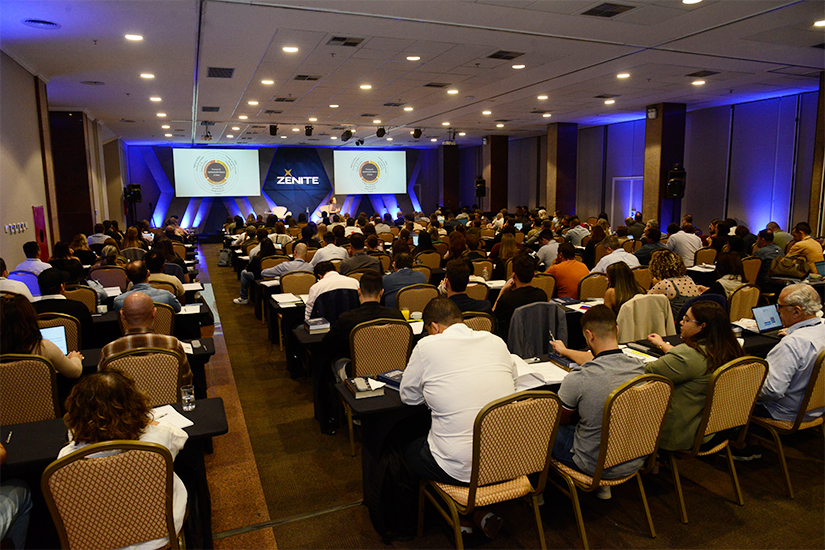 Auditório com participantes em evento da Zênite